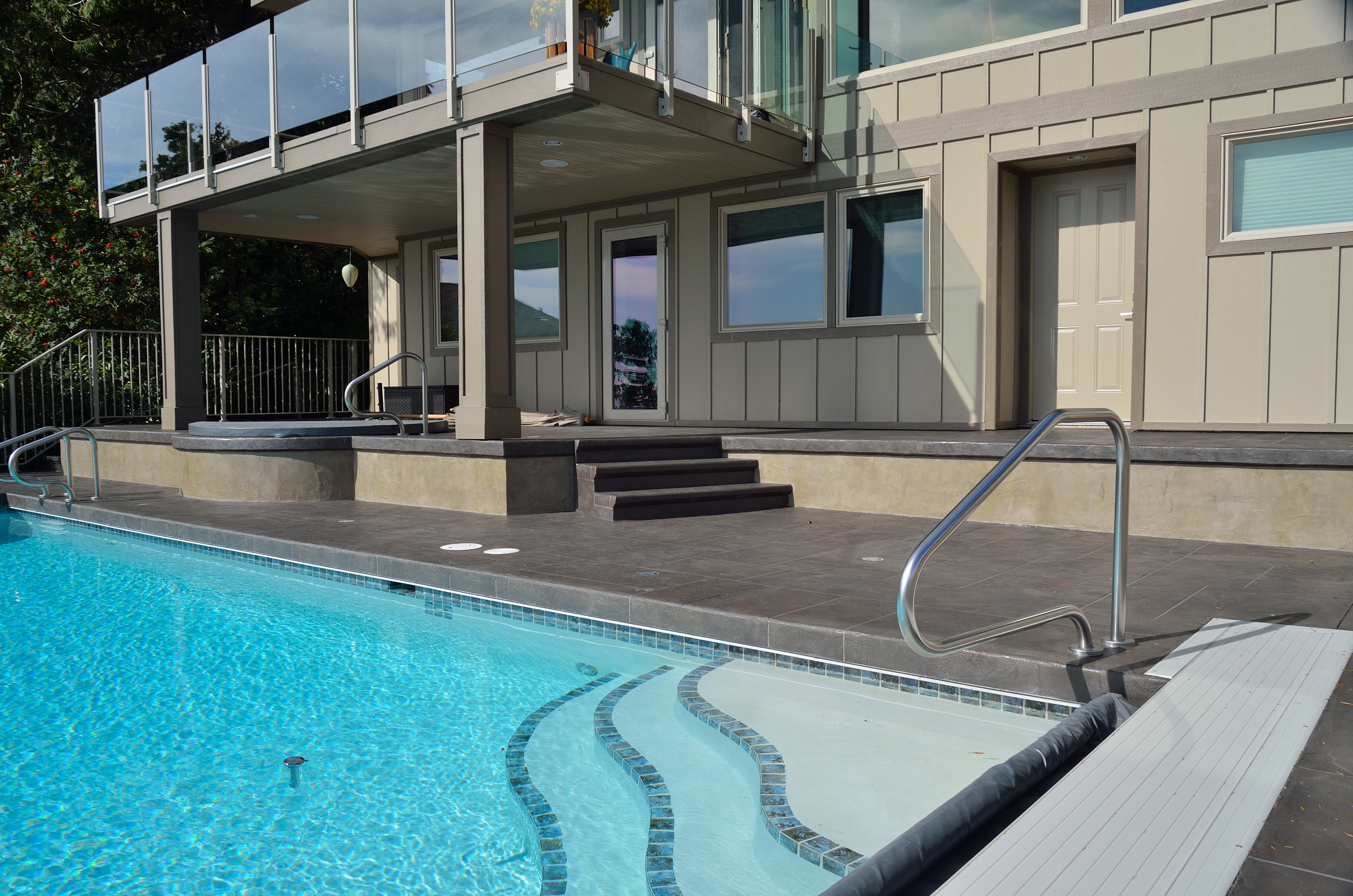 Modern slate-style StoneCraft pool deck with mosaic accent detail
