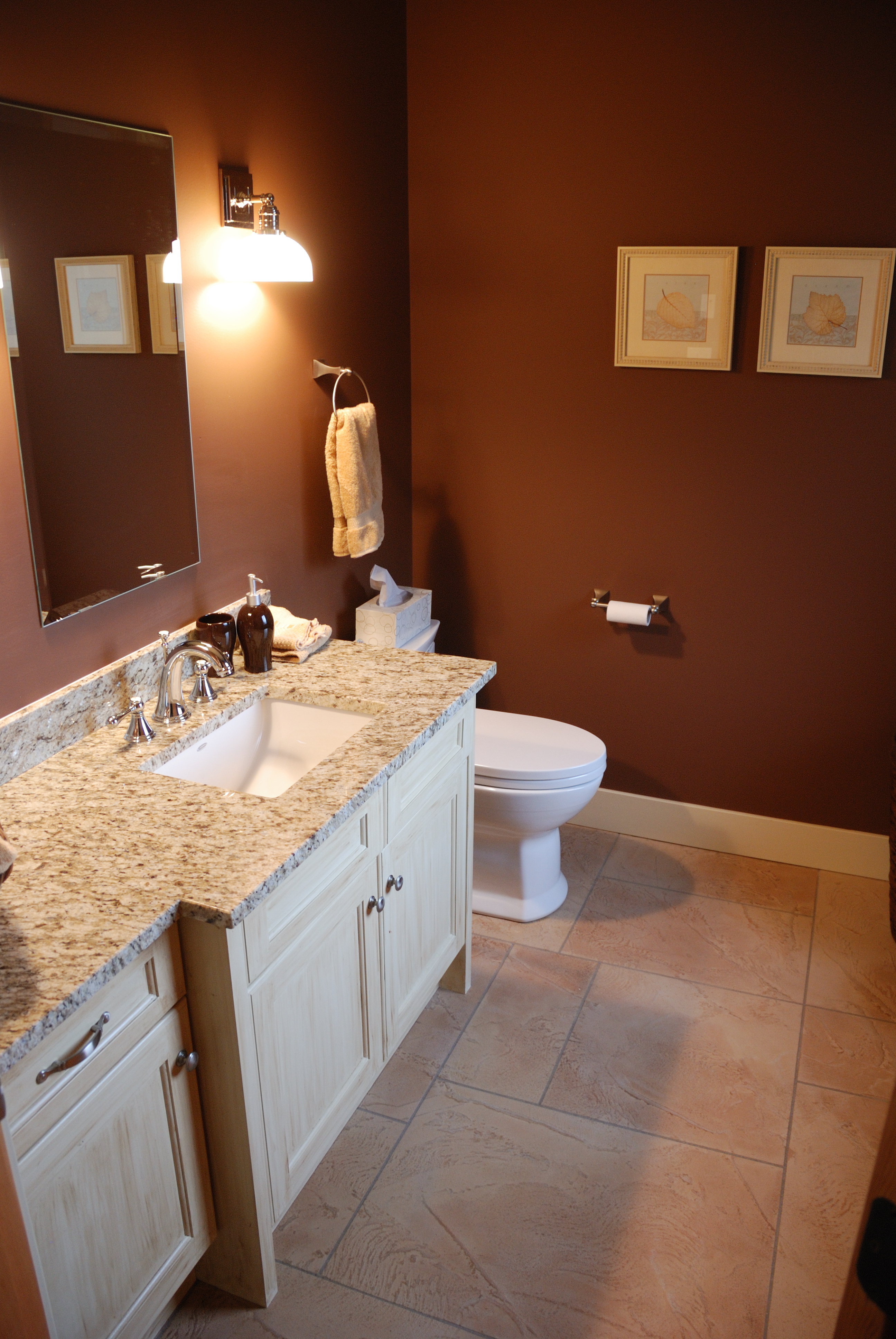 Powder room with warm sandstone StoneCraft flooring and granite vanity